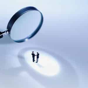 Close-up of magnifying glass focusing on two people Finding the right franchise business for you