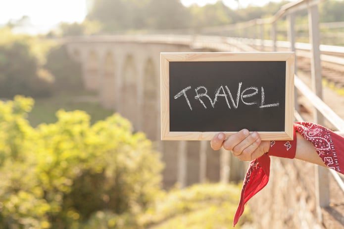 hand holding a board with the word travel