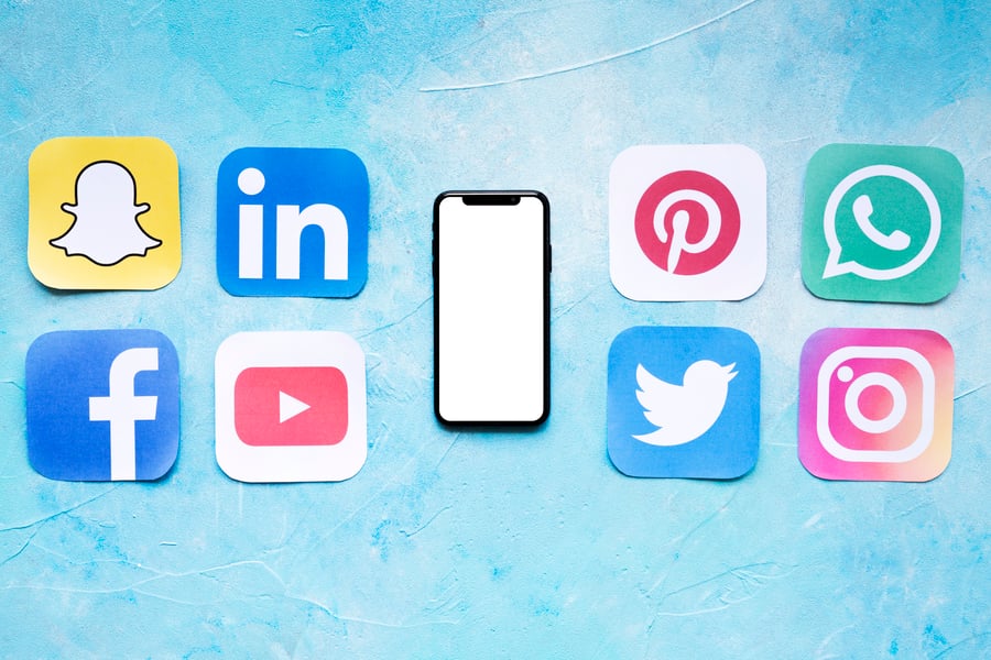 set of social media icons near a mobile device